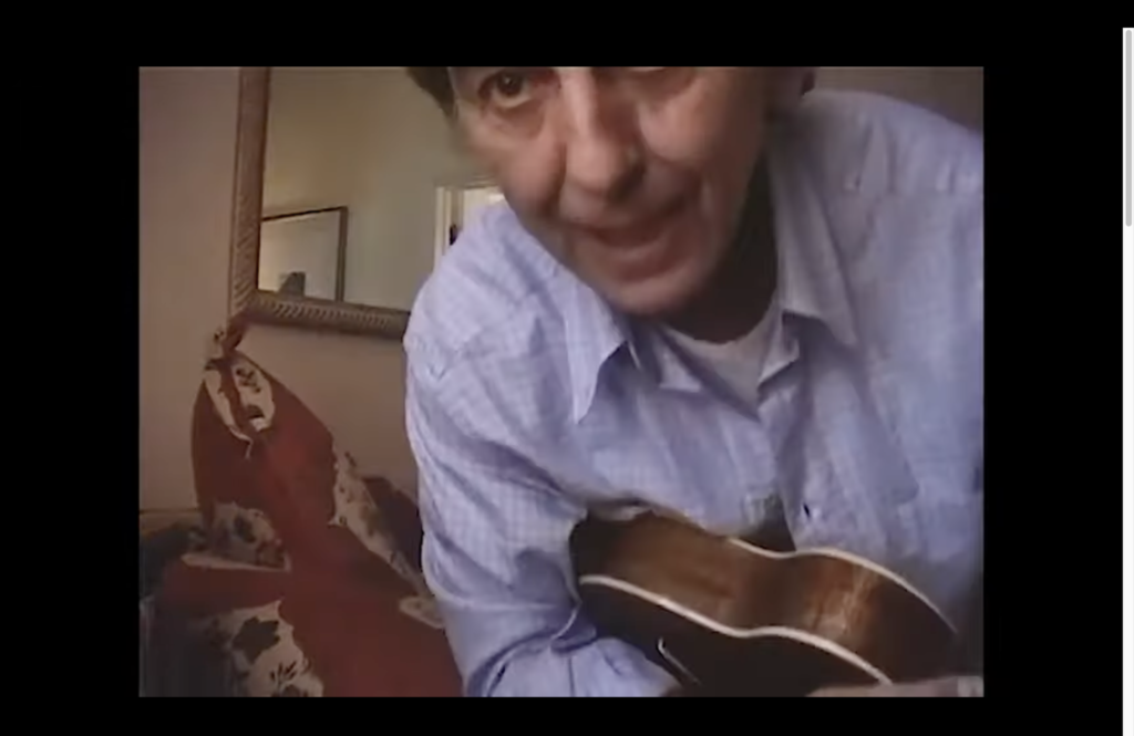 Screen grab from a video showing a man hlding a ukulele